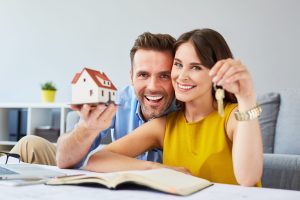 Happy couple holding keys to new home.